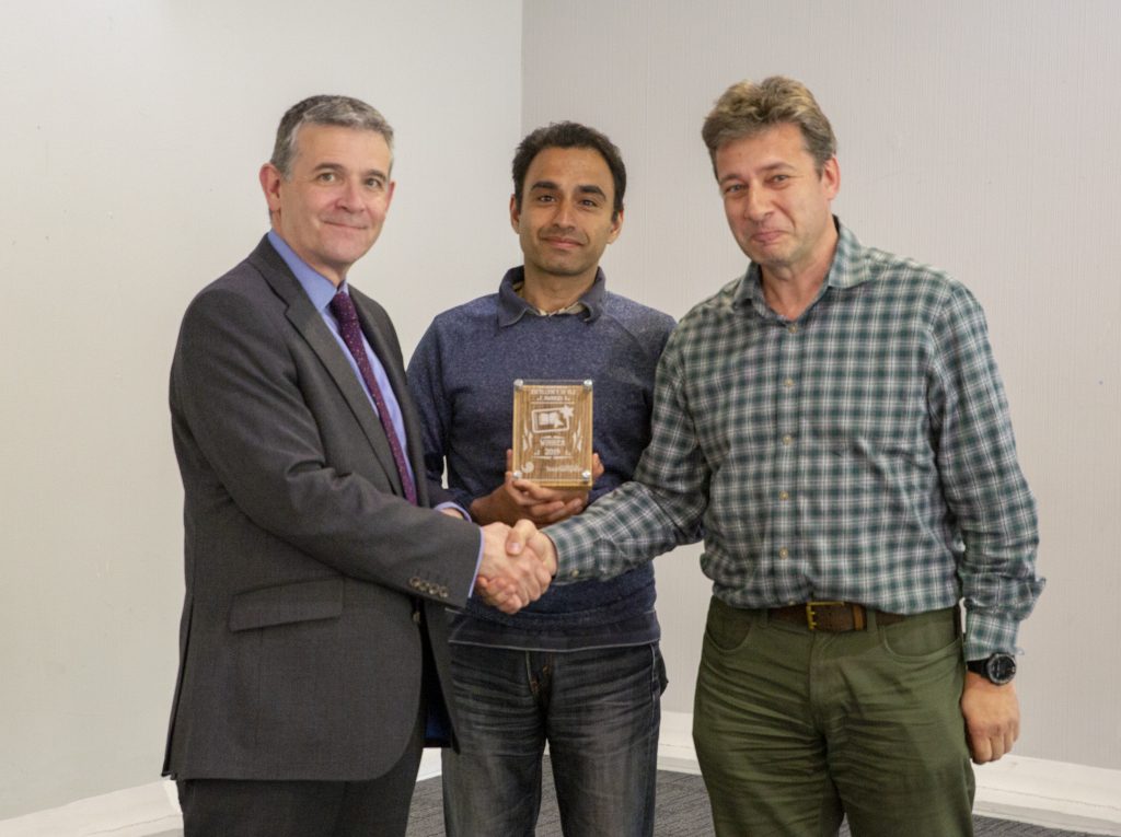 Prof Alex Neill presents the award to Dr Francesco Shankar and Prof Alexander Belyaev 