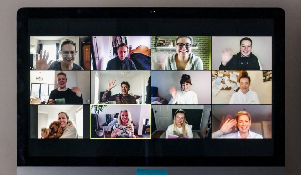 Image of a team conference call on a computer screen in a home office.