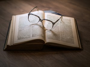 Photo of a glasses on top of a book, symbolising knowledge about Neolithic ditched enclosures.