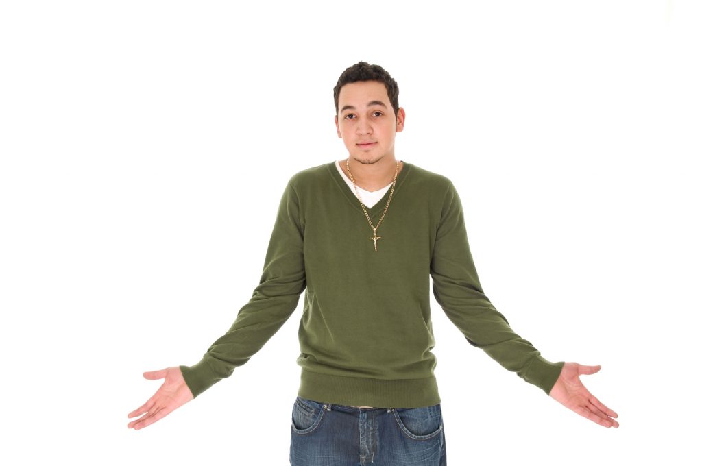 a young man wearing turtle nack shirt with his arms wide open