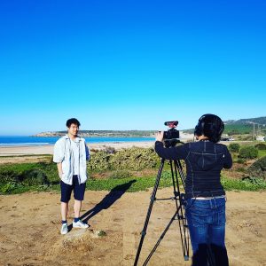 Camera crew and a subject at the beach.