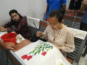 Ms Haitao Cheng painting roses.