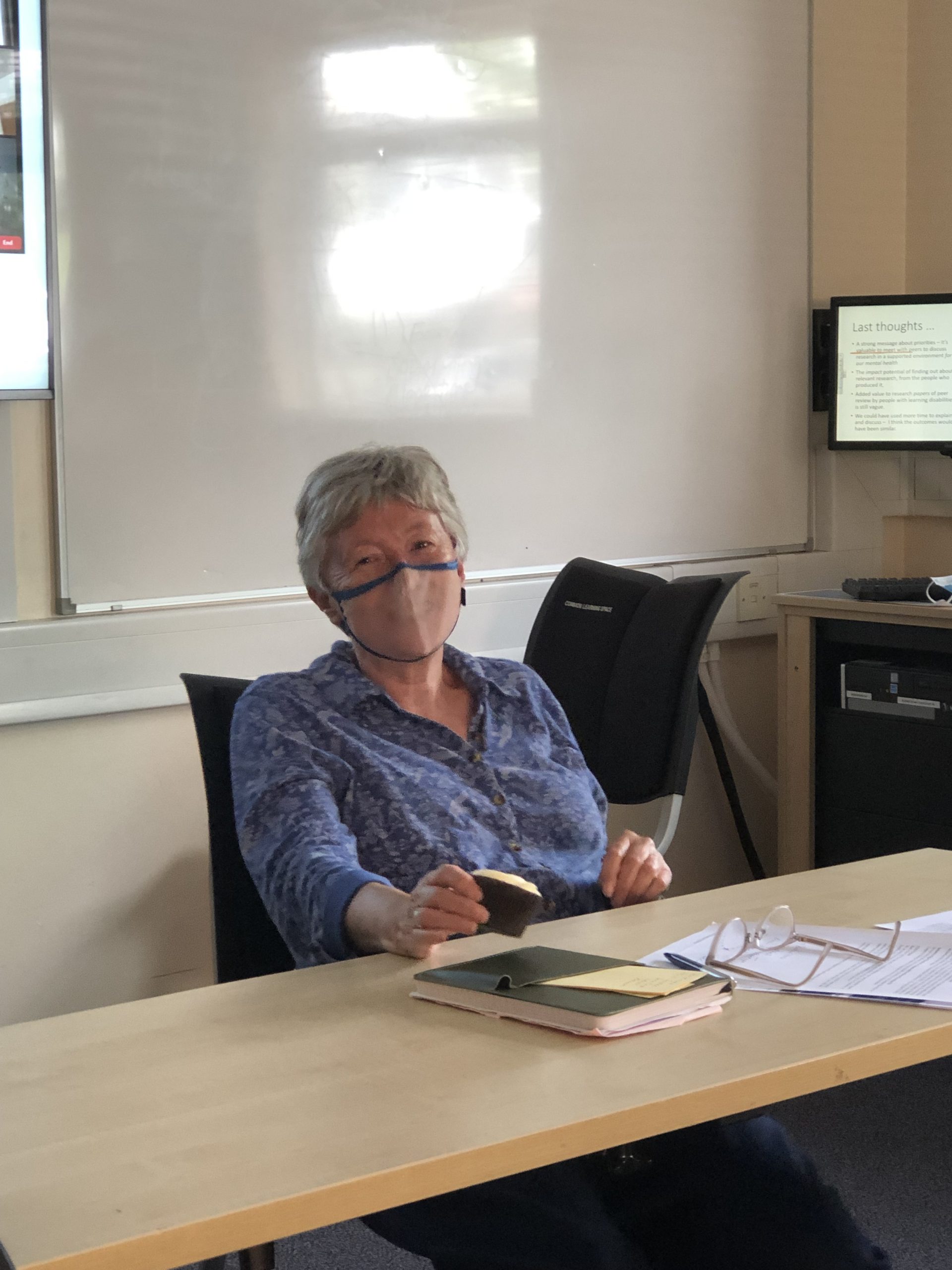 An image of Professor Melanie Nind with a mask, sitting on a chair 