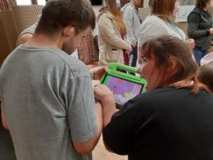 Two participants exploring an activity on an iPad and animatedly enjoying their interaction. 