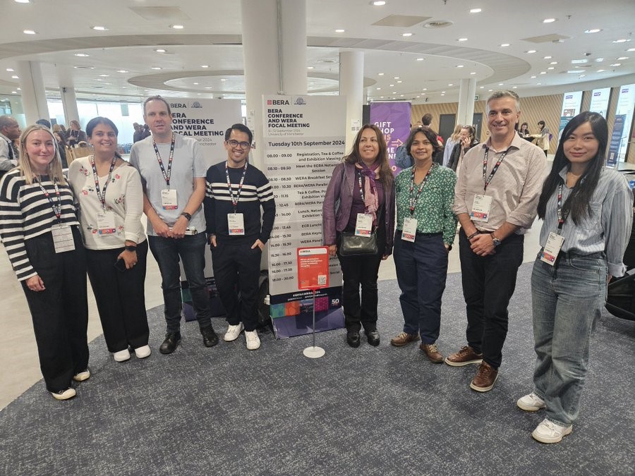 A group of people standing in front of a vertical poster