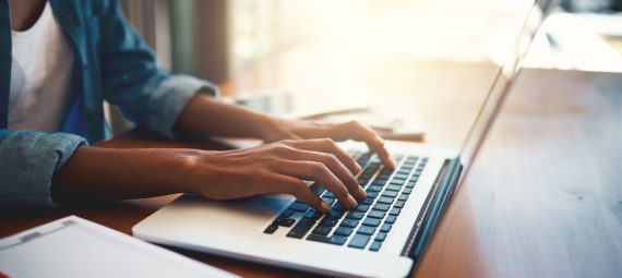 Close up shot of a woman using a laptop.