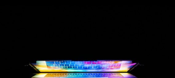 Slightly open laptop showing a coloured glow on the keyboard.