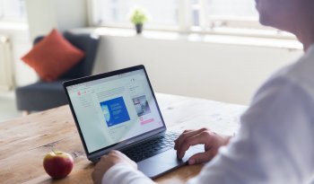 person using macbook pro on table