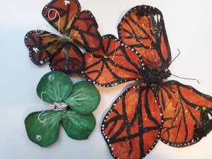 Three model butterflies created by members of the public. One is green and the other two are traditional monarch butterfly colours and patterns.