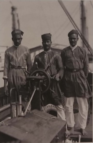 Three Lascars standing on the ship  Viceroy of India from Kushner. The men are dressed in traditional attire with long tunics and head coverings. 