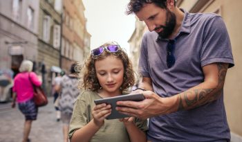 Father and son exploring the city with a digital tablet