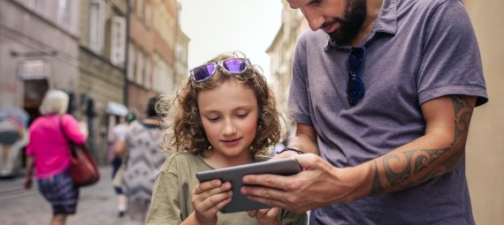 Father and son exploring the city with a digital tablet