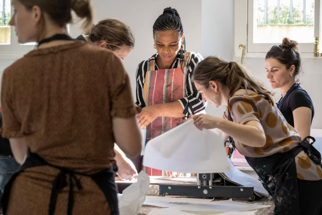 5 women engaged in printmaking